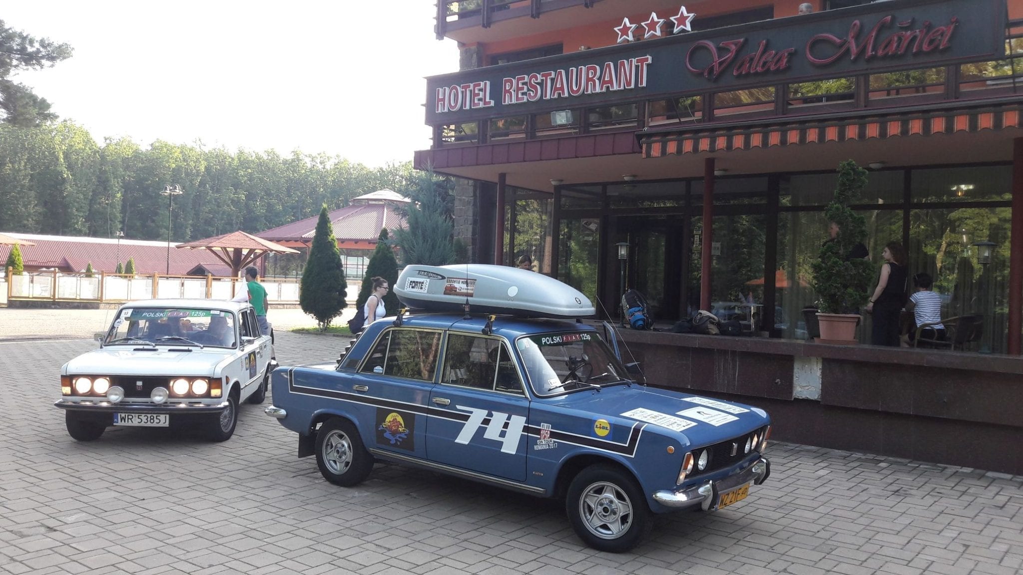 Stare samochody przed hotelem.