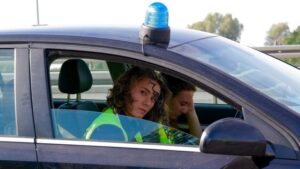 Policjanci w radiowozie na drodze.