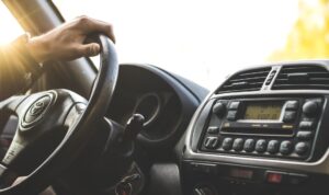 Ręka na kierownicy, radio samochodowe.