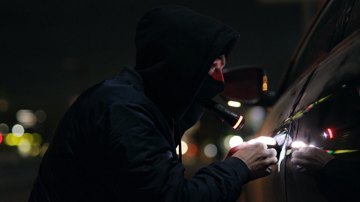 Złodziej próbuje otworzyć samochód.