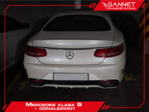 Tył białego Mercedesa klasy S na parkingu